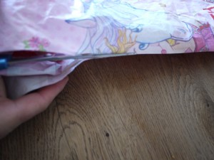 Drachen basteln mit Kindern ist Schneidearbeit: Nun schnippeln wir eine Seite der Plastiktüte in der Mitte durch. Foto (c) kinderoutdoor.de